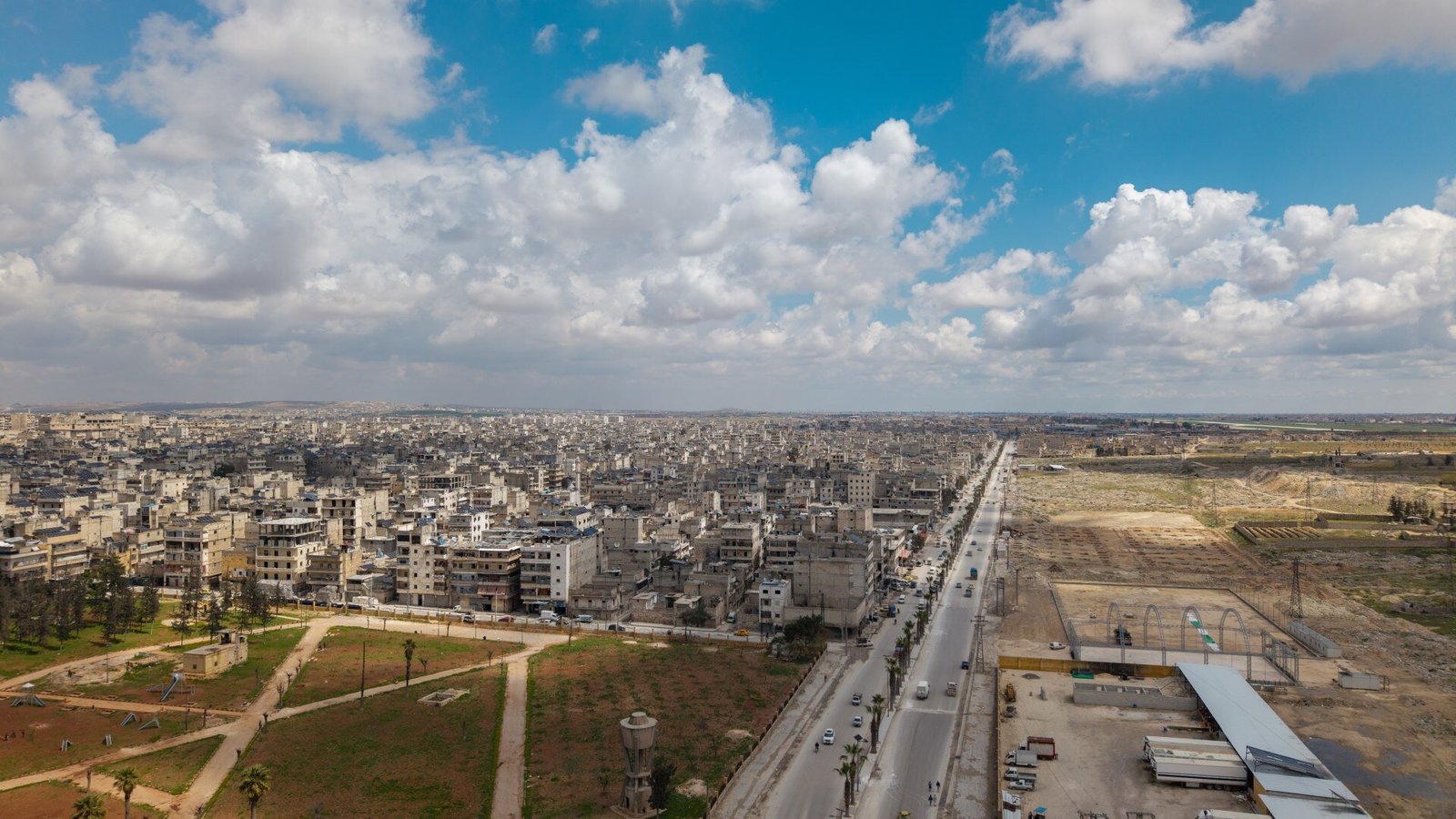 Aerial view of Aleppo along a main road, dramatic clouds